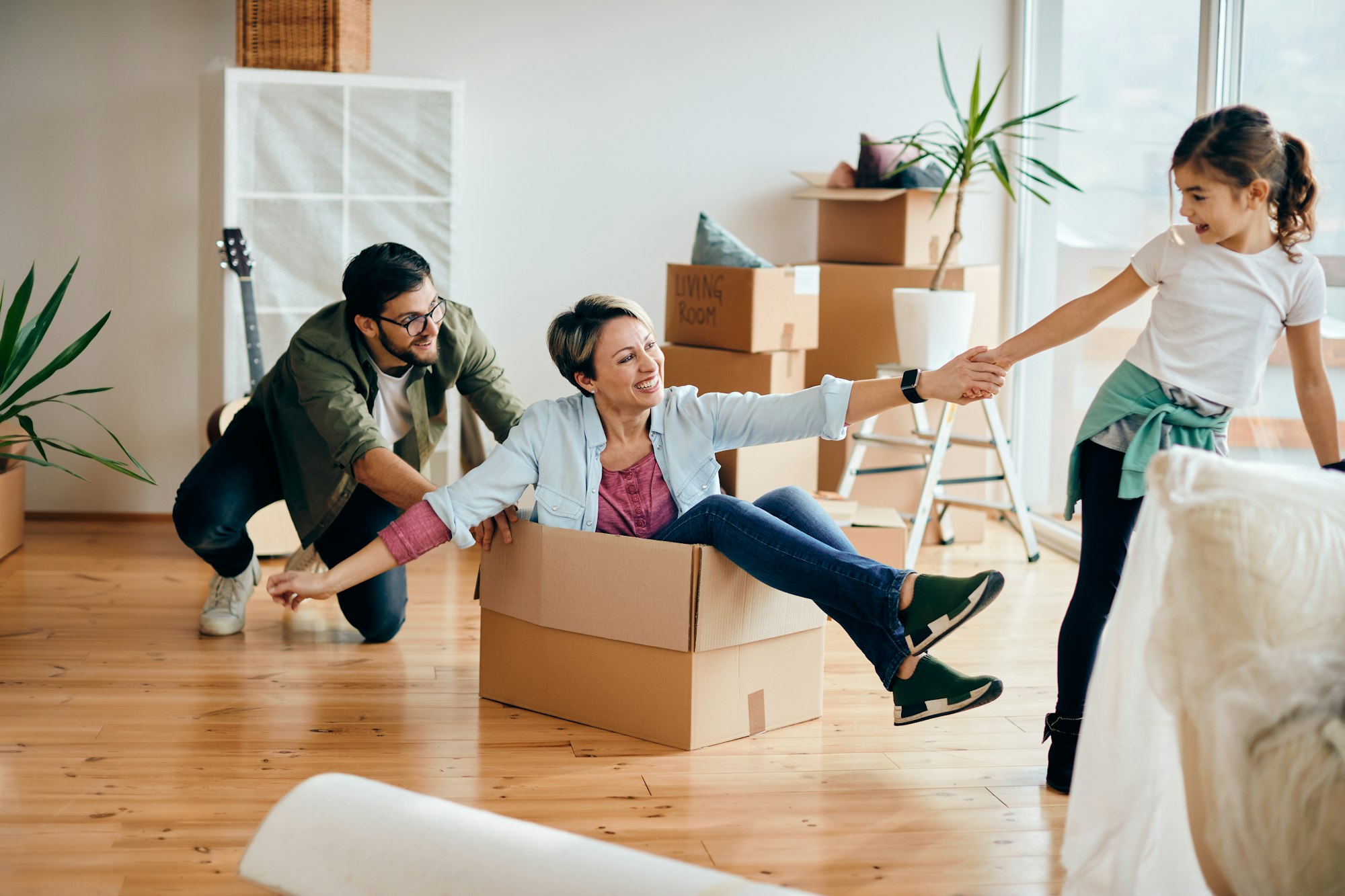 Playful family having fun together while moving into their new house.